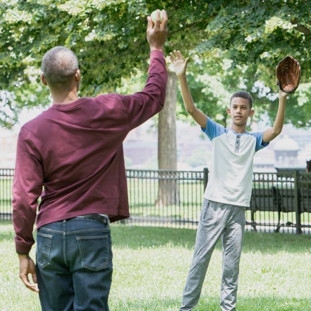 Common Questions-boy playing catch with caregiver