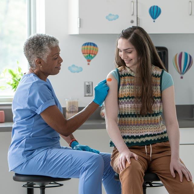 Common Questions- doctor giving adolescent a vaccine