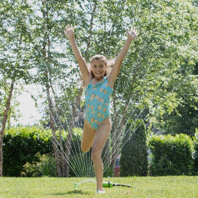 Common Questions-girl playing in sprinkler